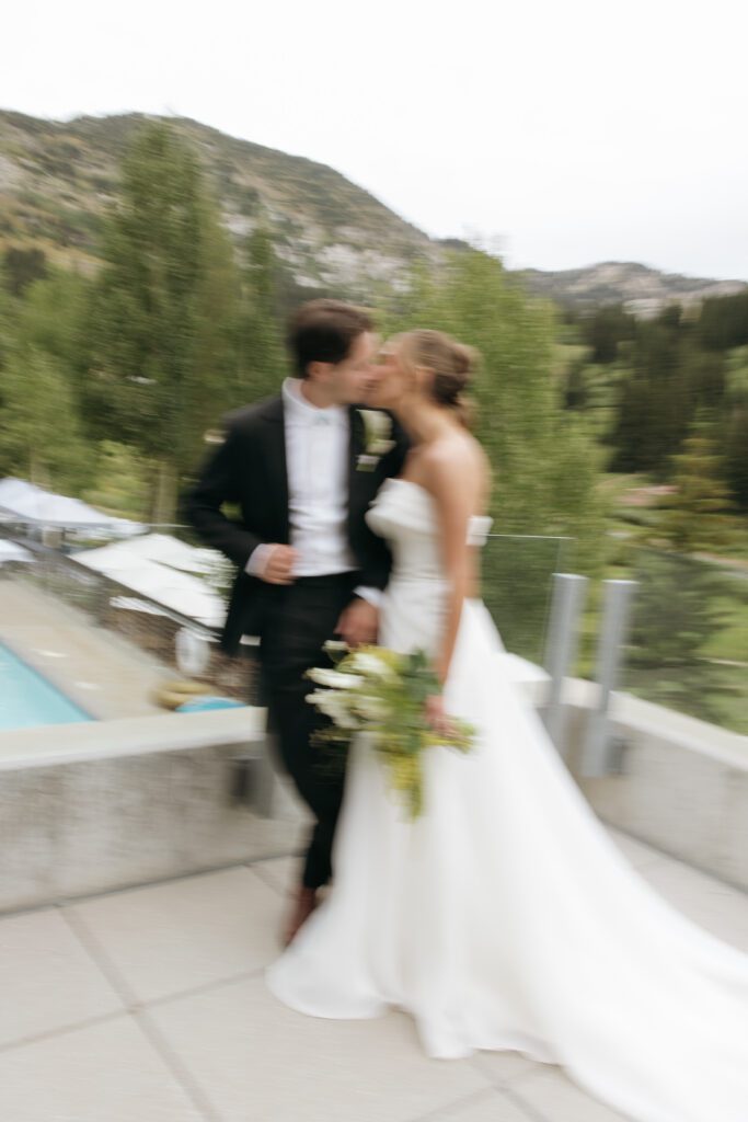 bride and groom kissing on balcony