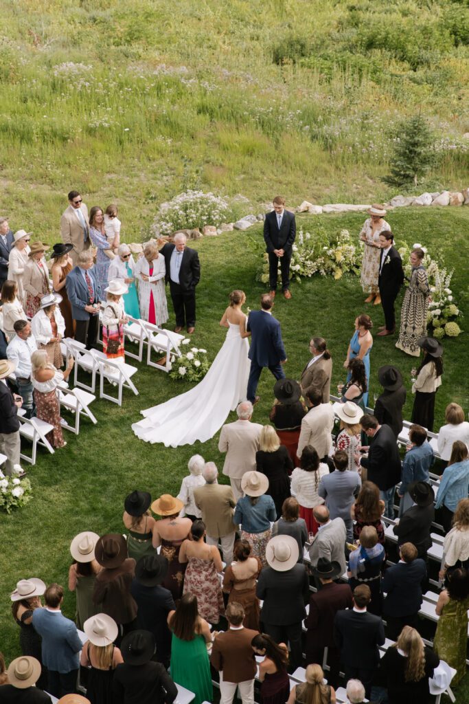 S and P during their Alta’s Rustler Lodge wedding ceremony with green mountains behind them.