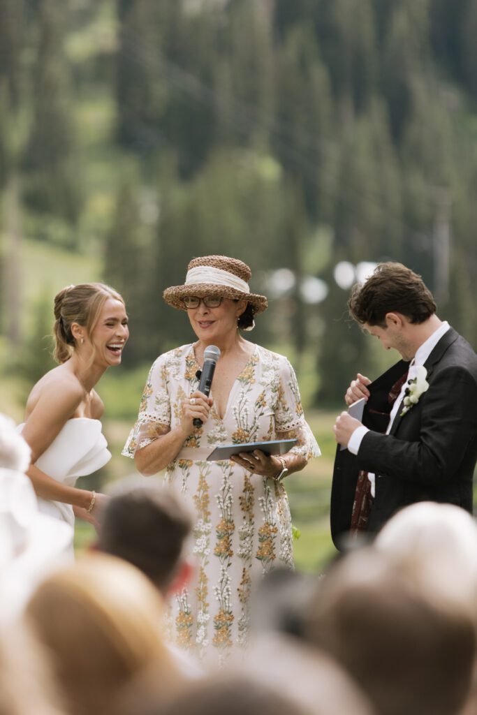 S and P during their Alta’s Rustler Lodge wedding ceremony with green mountains behind them.