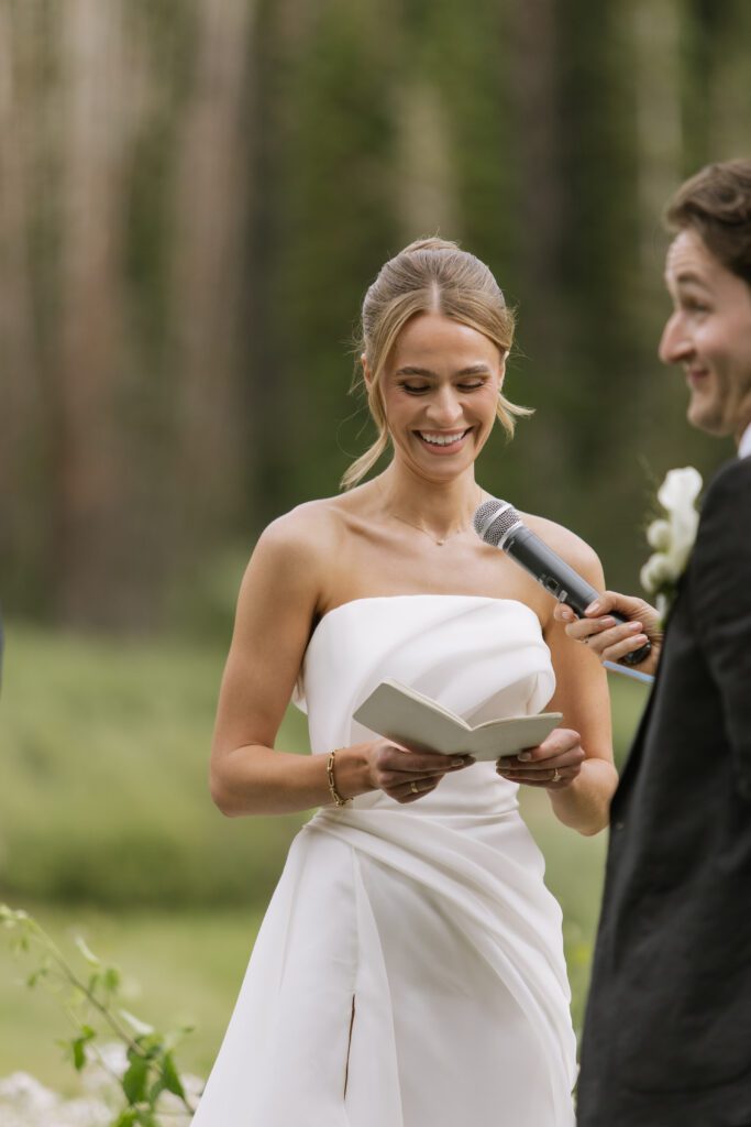 S and P during their Alta’s Rustler Lodge wedding ceremony with green mountains behind them.
