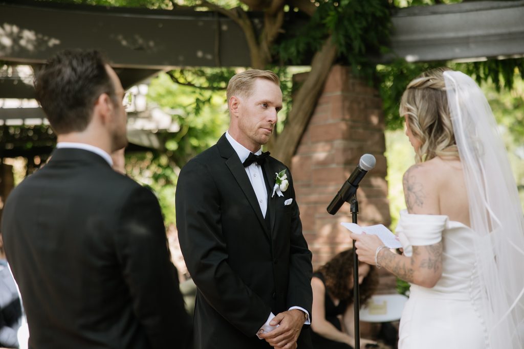 Groom listening to bride's vows.
