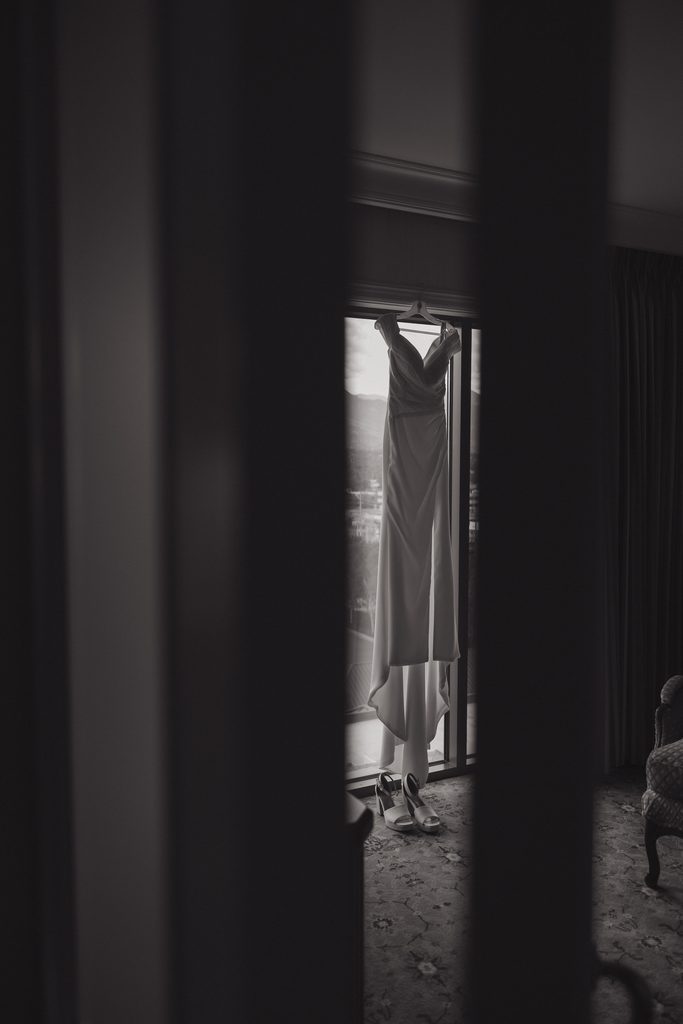 Wedding dress hanging in window of hotel room