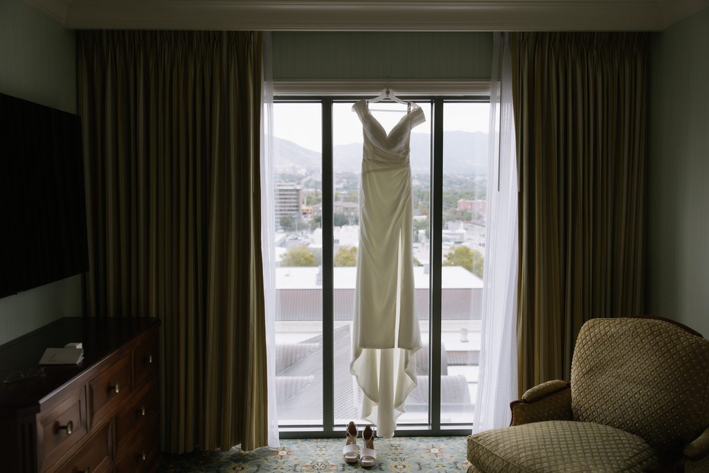 Wedding dress hanging in window of hotel room